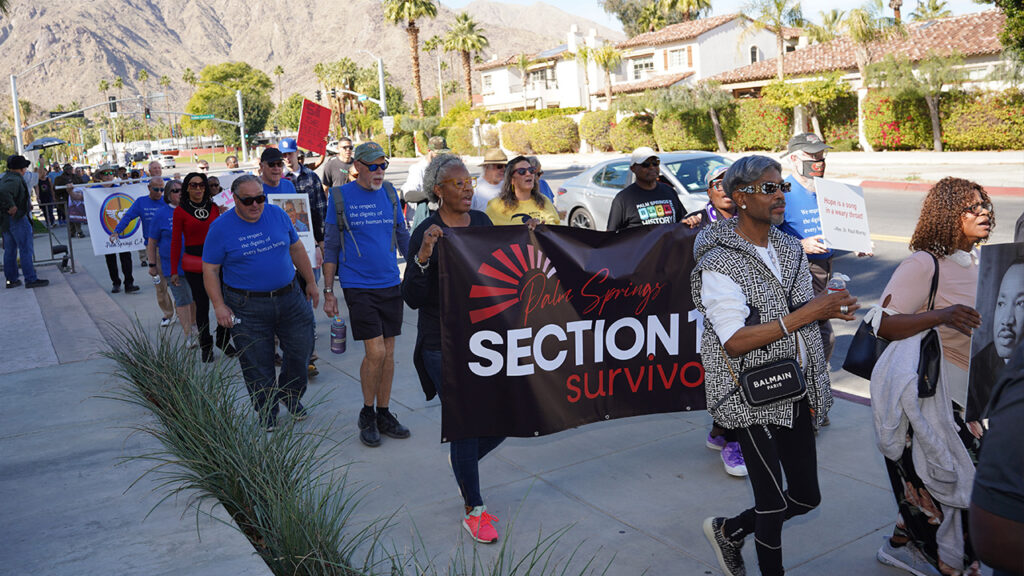 people marching on Martin Luther King Day in Palm Springs carrying a Section 14 banner